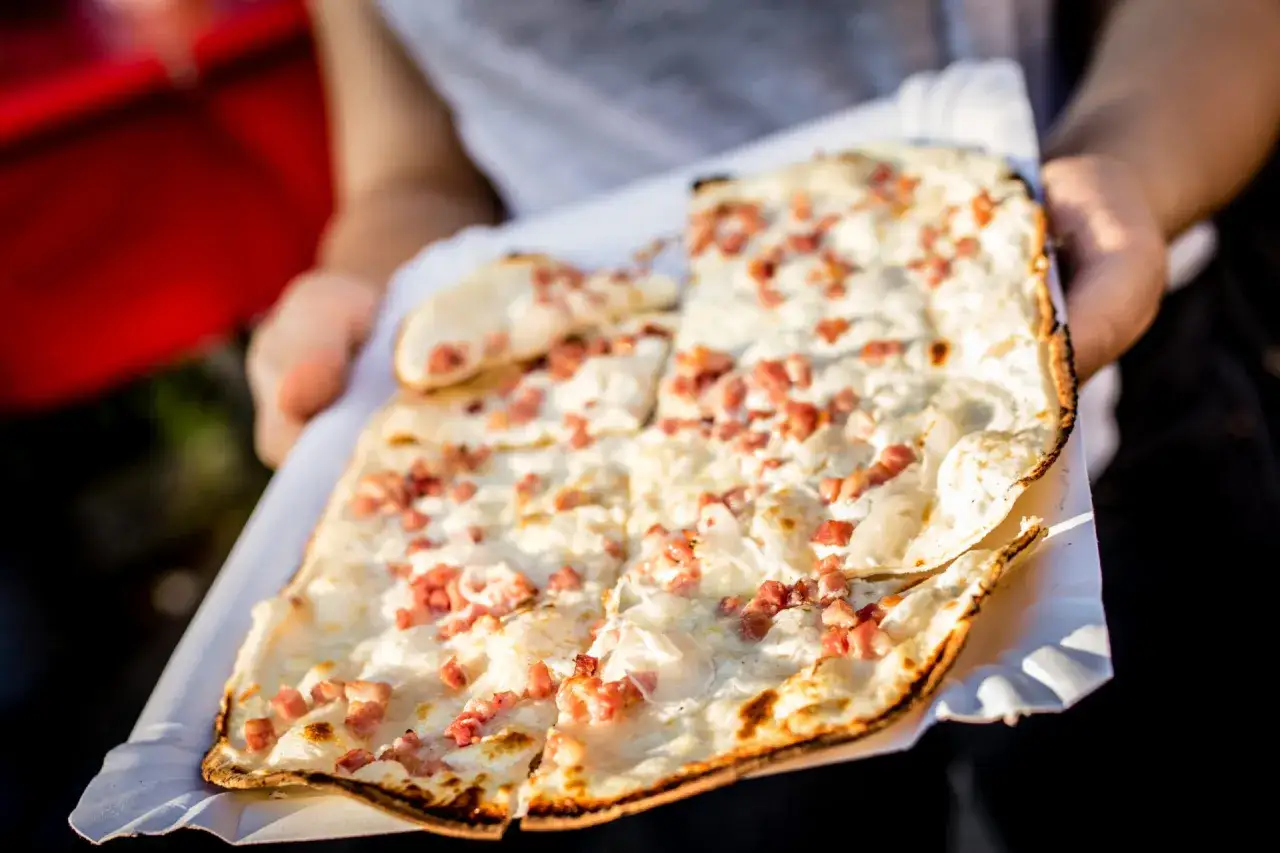 Flammekueche traditionnelle, une pâte fine garnie de crème, lardons et oignons. La vraie recette flammekueche pour un plaisir authentique.