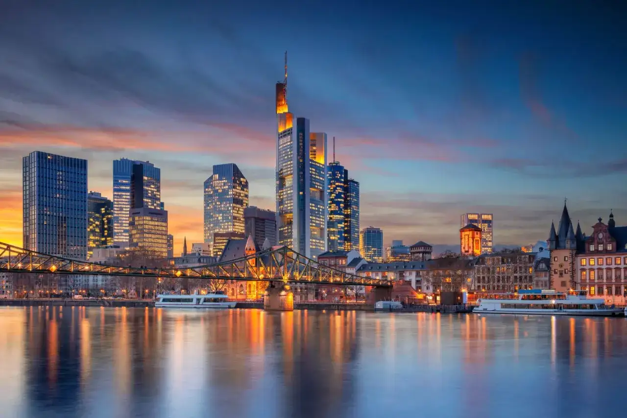 Frankfurter Skyline bei Sonnenuntergang mit Main und Brücke.