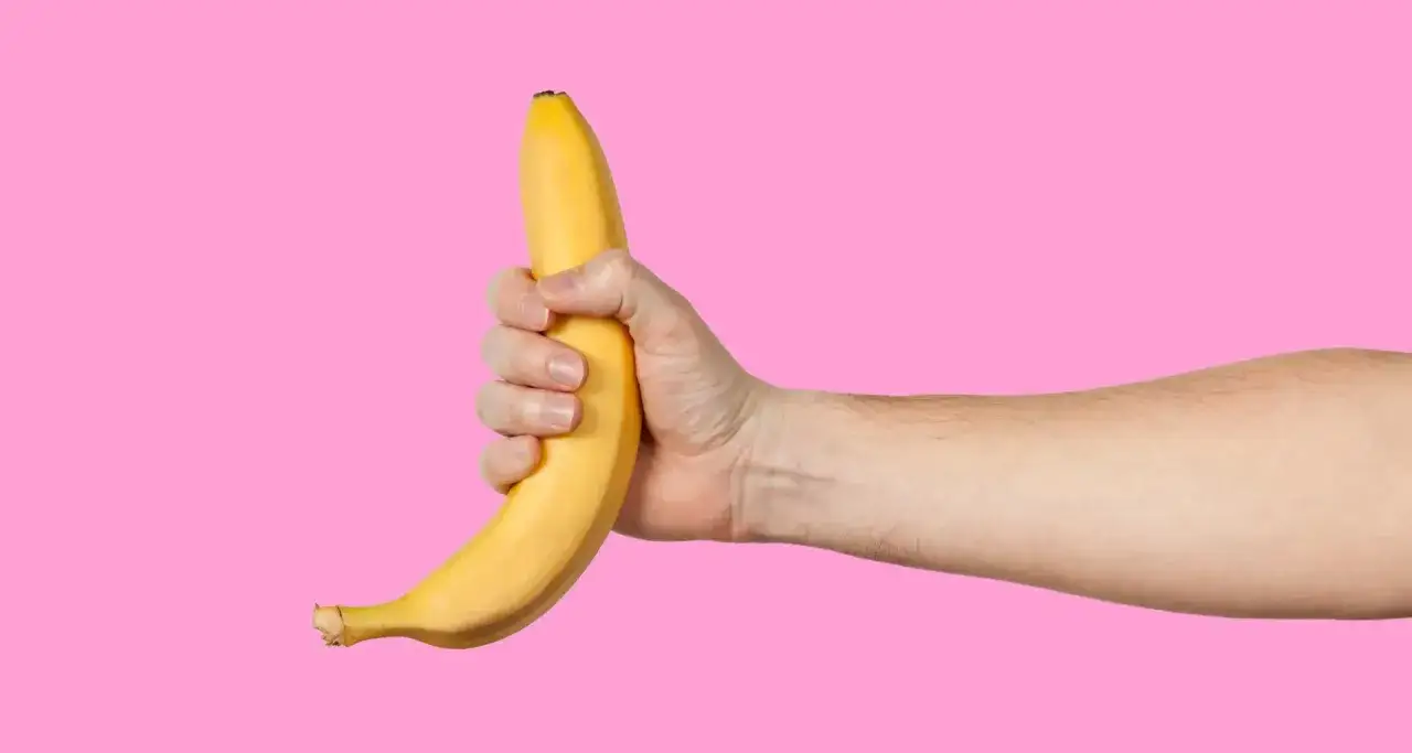 Dłoń trzymająca banana, sugerująca pozycje do masturbacji.