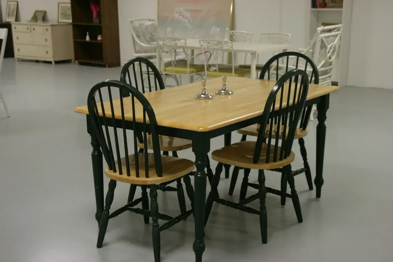 Drewniany stół z zielonymi krzesłami, idealny pomysł na jadalnie. Dwa świeczniki na blacie dodają elegancji.