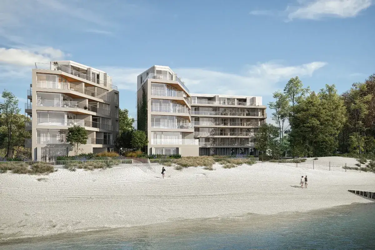 Nowoczesne apartamenty nad morzem, które mogą stracić na wartości od 2026 roku. Widok na plażę i budynki z balkonami.