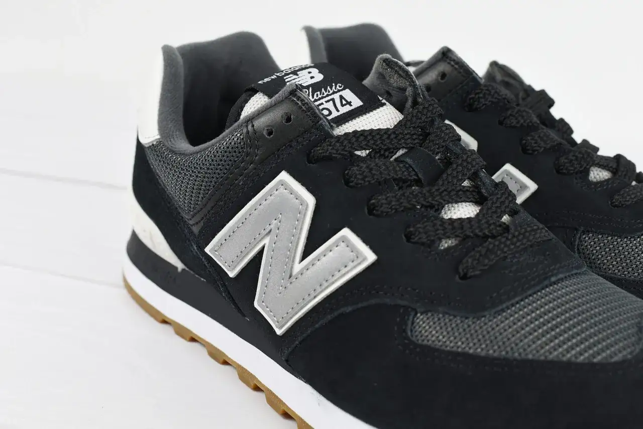 Czarne buty New Balance 574 z szarym logo "N" i gumową podeszwą. Czy Sizeer ma oryginalne buty? Tak, te wyglądają na autentyczne.