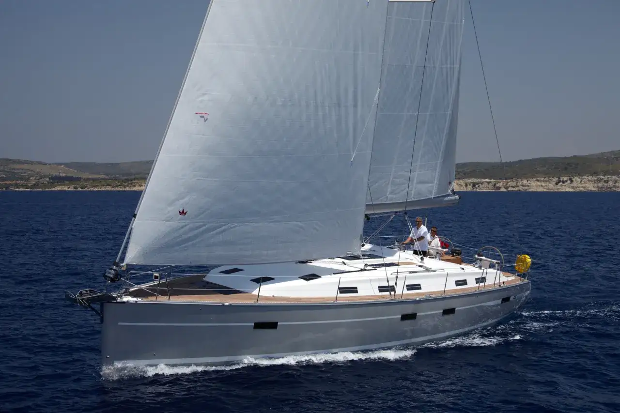 Die **Segelyacht Andromeda** gleitet majestätisch über das tiefblaue Meer, zwei Segel sind gesetzt, zwei Männer am Steuer.