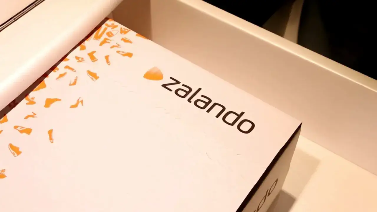 Pudełko z logo Zalando, ozdobione pomarańczowymi sylwetkami butów. Ciesz się zakupami z zalando lounge darmowa dostawa!