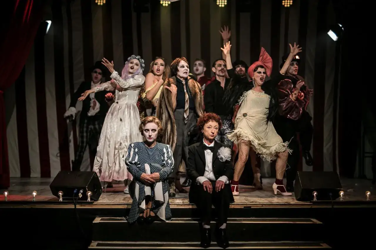 Aktorzy w teatralnych strojach na scenie w Warszawie. Lipiec przyniósł emocje na deskach teatru.