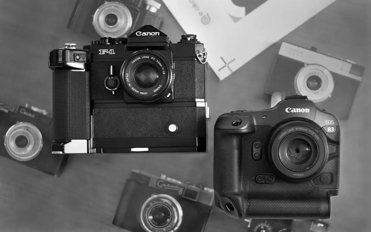 Dwa aparaty Canon: starszy model F-1 i nowoczesny EOS R3, otoczone innymi aparatami.