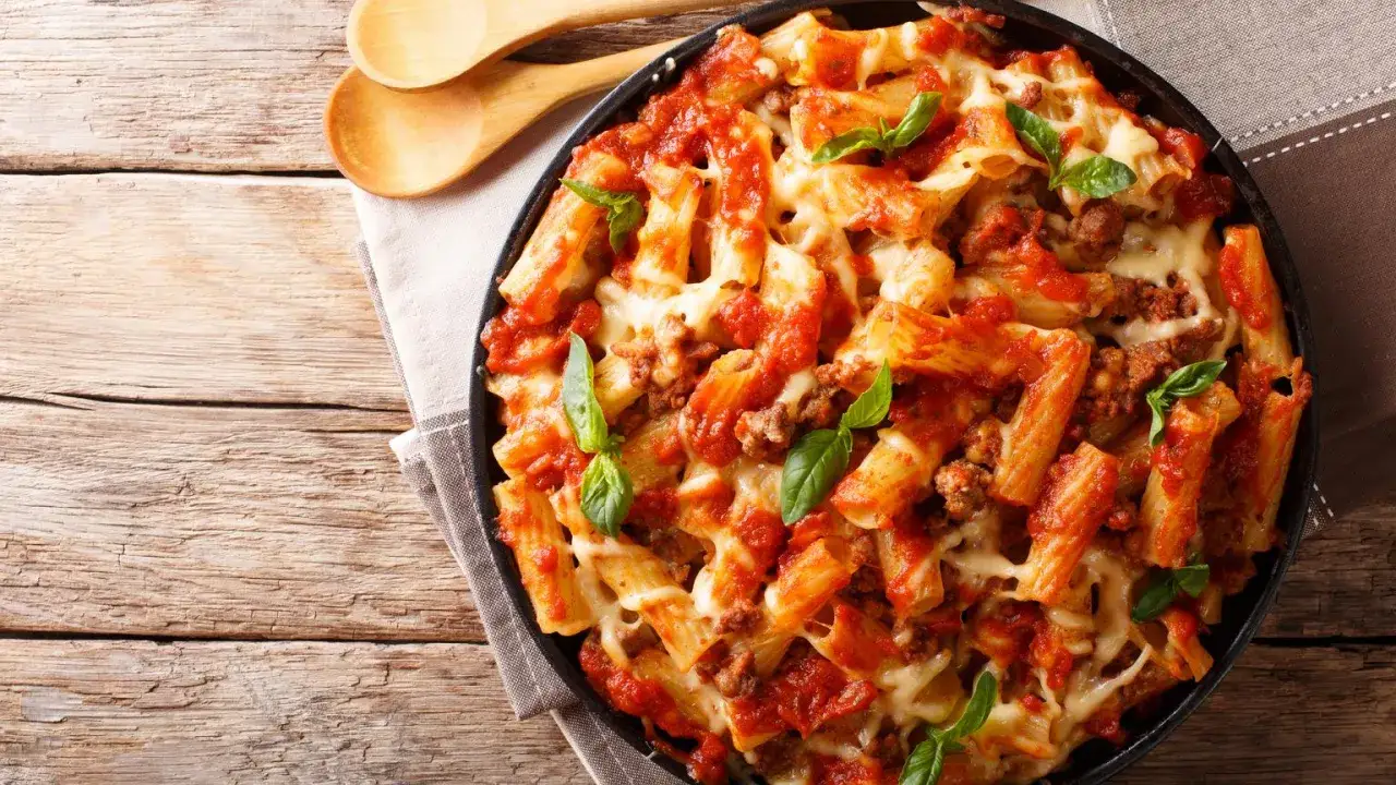 Pyszne danie z makaronem rigatoni, sosem pomidorowym i mięsem mielonym, zapieczone z serem. Idealne co na obiad z mięsa mielonego.