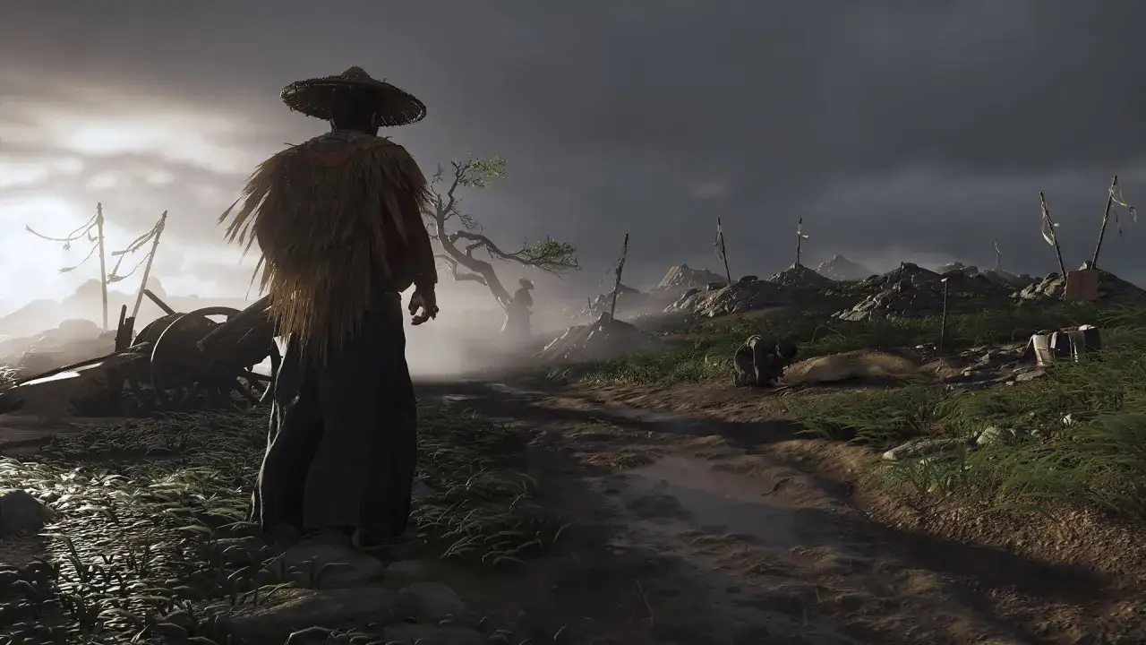 Samuraj w słomkowym kapeluszu stoi na poboczu drogi, obserwując pole bitwy z gry Ghost of Tsushima.