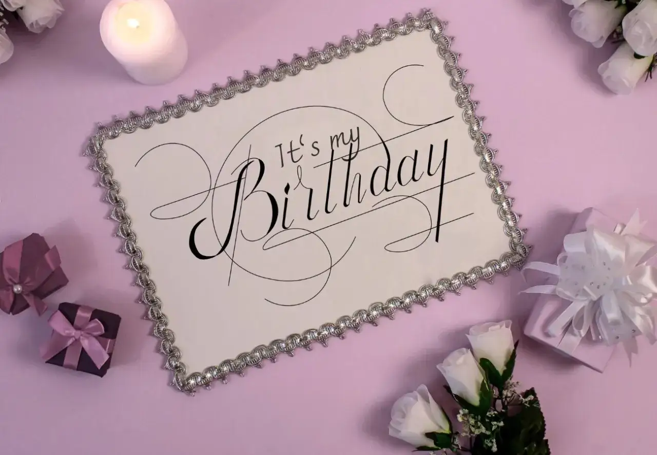 Eleganckie zaproszenie na urodziny w stylu savoir vivre. Biała kartka z ozdobnym napisem "It's my Birthday", otoczona prezentami i świecą.