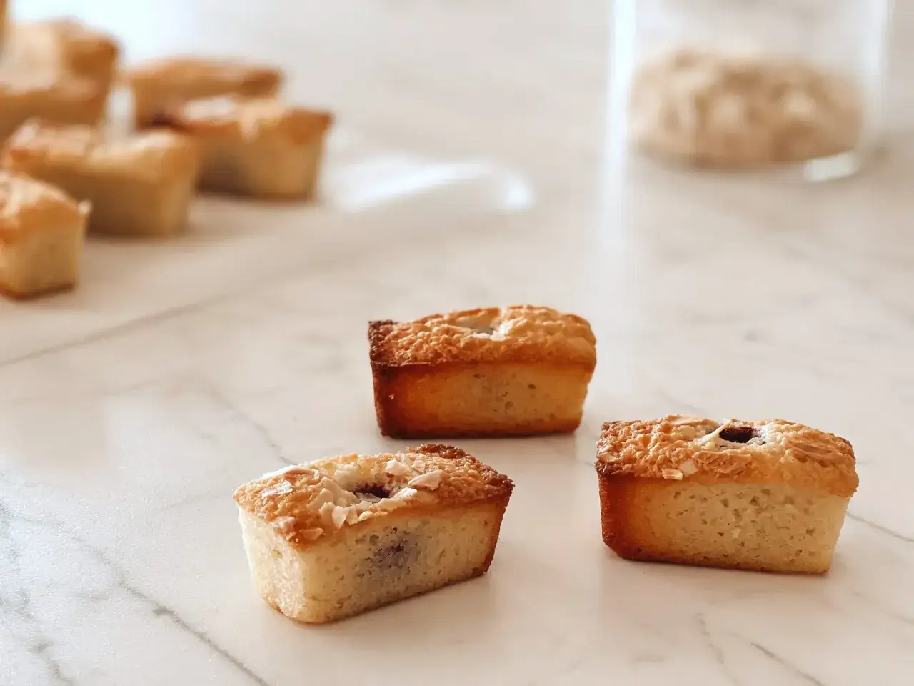 Financiers dorés, parfaits pour une recette financier framboise. Ils sont garnis de fruits rouges et de flocons d'amandes.