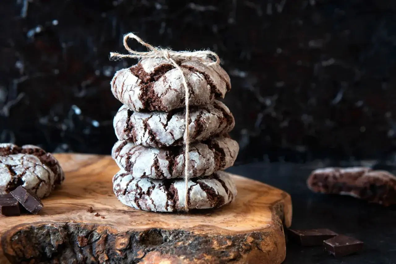 Pile de craquelins au chocolat, parfaits pour une recette facile. Ils sont liés par une ficelle et posés sur une planche en bois.
