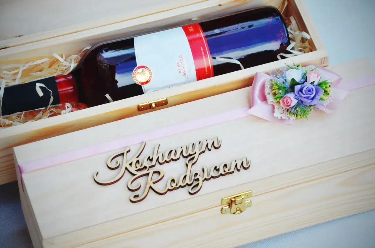 Elegancka skrzynka na wino dla chrzestnych z napisem "Kochanym Rodzicom" i ozdobną kokardką z kwiatami.