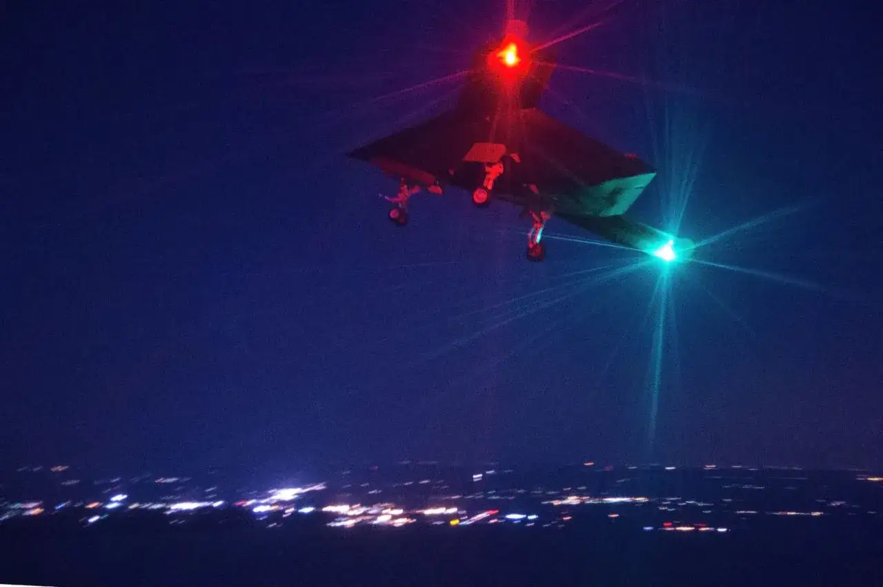 Nocny patrol: jak wygląda dron policyjny w nocy, z czerwonym i zielonym światłem, nad miastem.