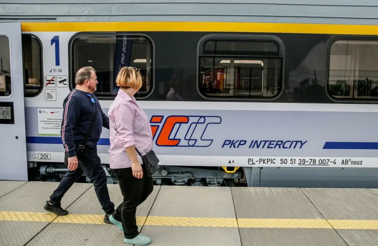 Para podróżuje obok pociągu PKP Intercity, który może zabrać ich z Rzeszowa do Krakowa.