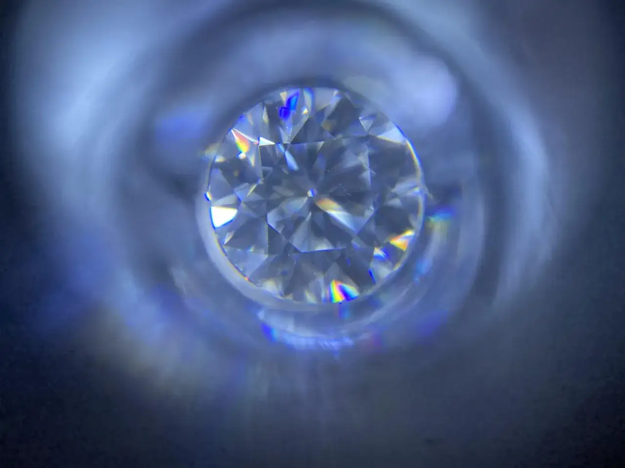 Błyszczący moissanit, co to jest? Kamień o tęczowych refleksach, przypominający diament, widziany z bliska.