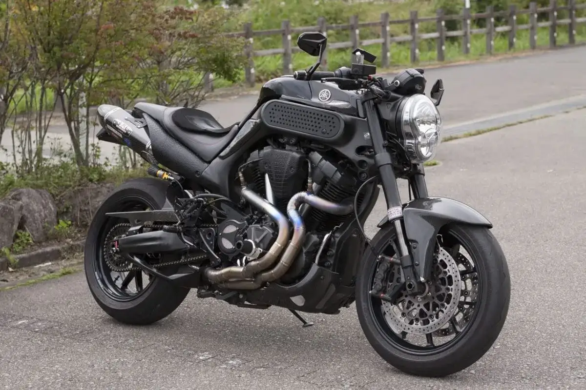 Czarny Yamaha MT-01 z customowym wydechem i sportowymi dodatkami, gotowy na jazdę po krętych drogach.