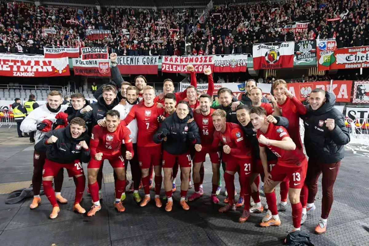 Radosna me grupa polska w czerwonych strojach świętuje z kibicami.