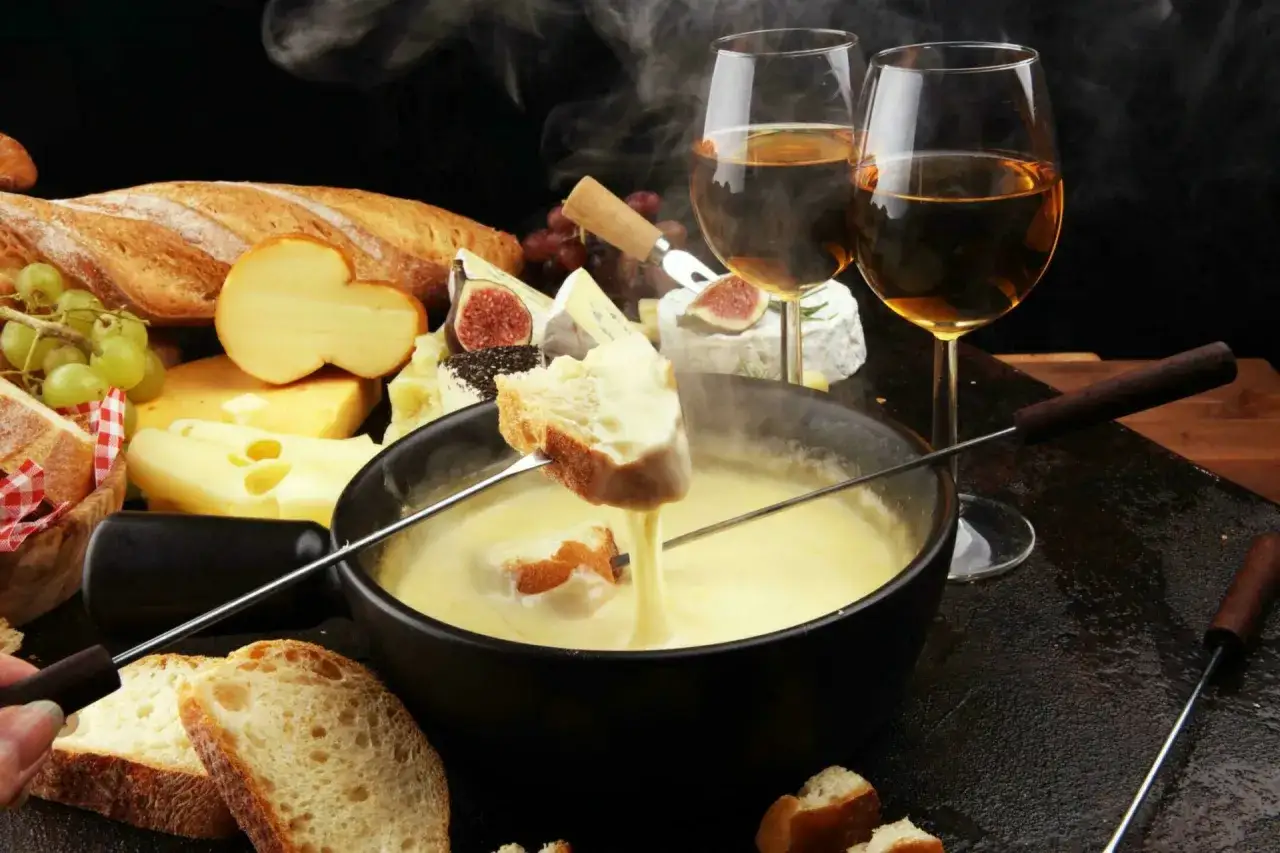 Un délice fumant de fondue au fromage, pain croustillant et vin blanc. Un aperçu des spécialités Auvergne Rhône Alpes.