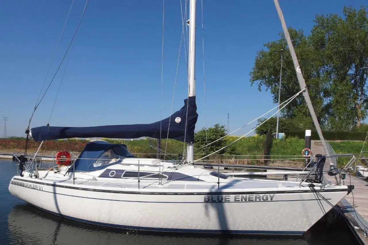 Weiße Segelyacht "Blue Energy" mit blauem Segel, liegend am Steg. Interessante dehler 31 technische daten für Segelfreunde.