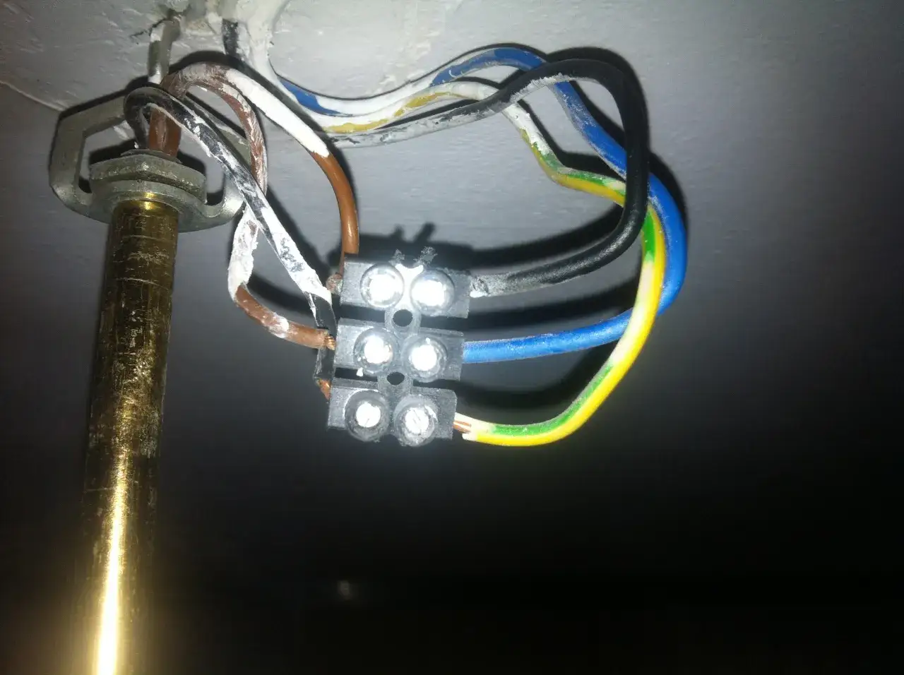 Widok z bliska na połączenie przewodów elektrycznych żyrandola z kostką.