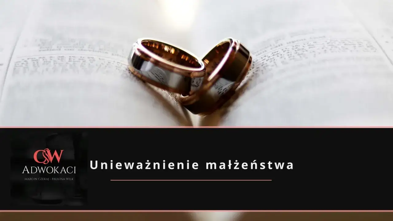 Dwa obrączki na otwartej księdze symbolizują rozważania o **unieważnieniu małżeństwa**.
