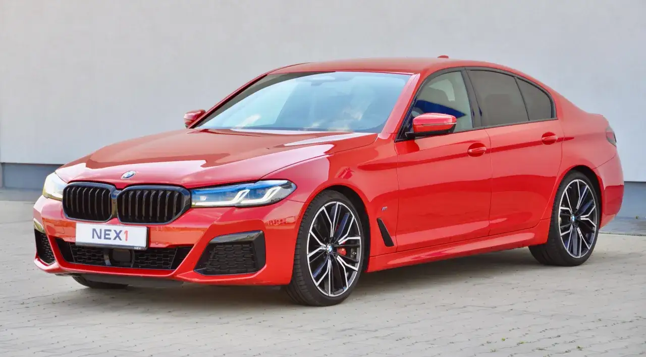 Czerwone BMW M550i z czarnymi felgami i sportowym pakietem.