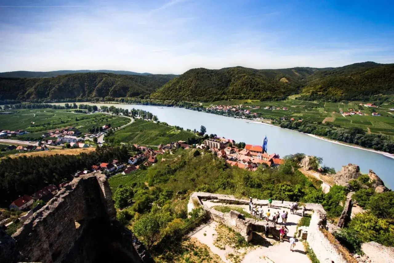 Widok na malowniczą dolinę Wachau z ruinami zamku, rzeką Dunaj i winnicami.