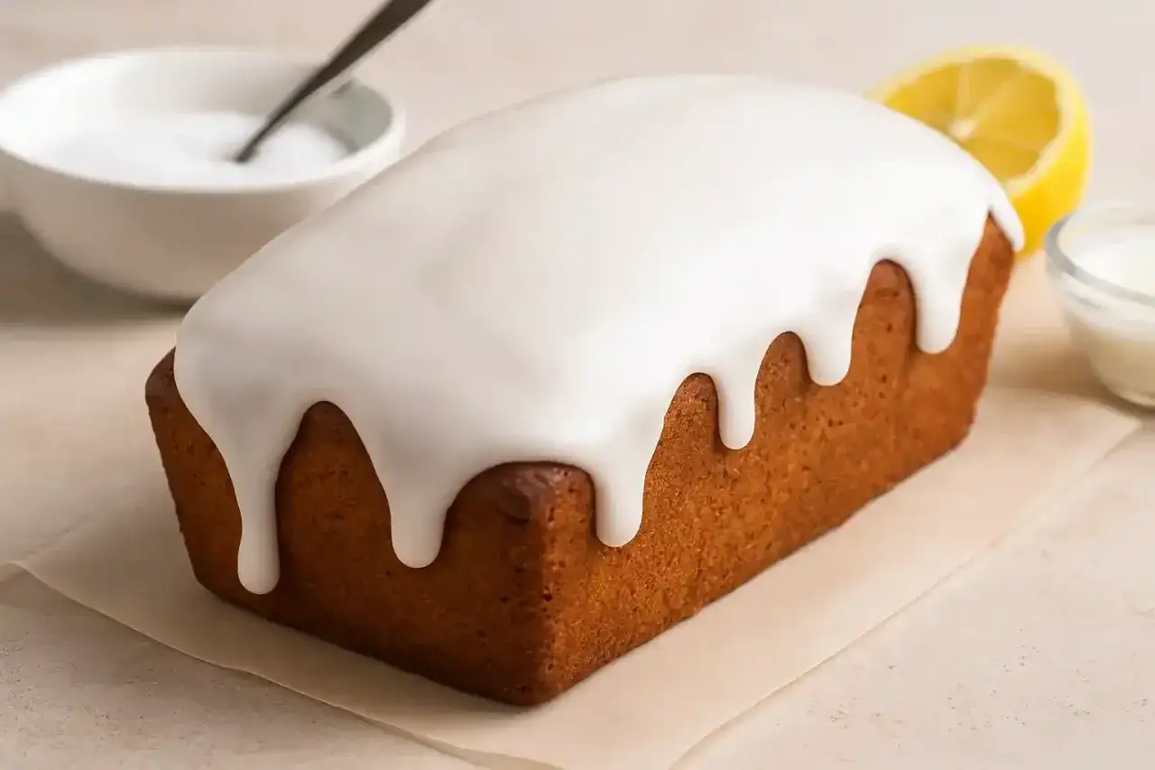 Un délicieux cake au citron avec un glaçage blanc dégoulinant. Parfait pour un glacage sur gateau froid ou chaud, il est prêt à être dégusté.