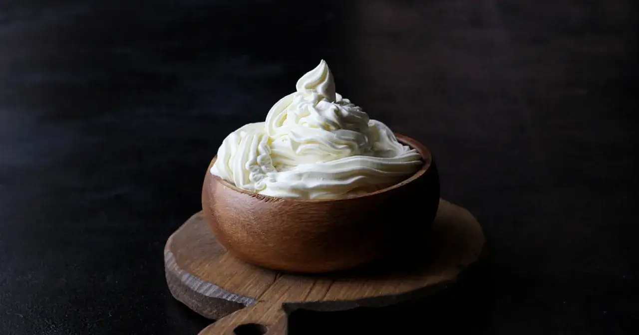 Kremowa masa w drewnianej miseczce, idealna do deserów. Mascarpone kontra serek homogenizowany – który wybierzesz?