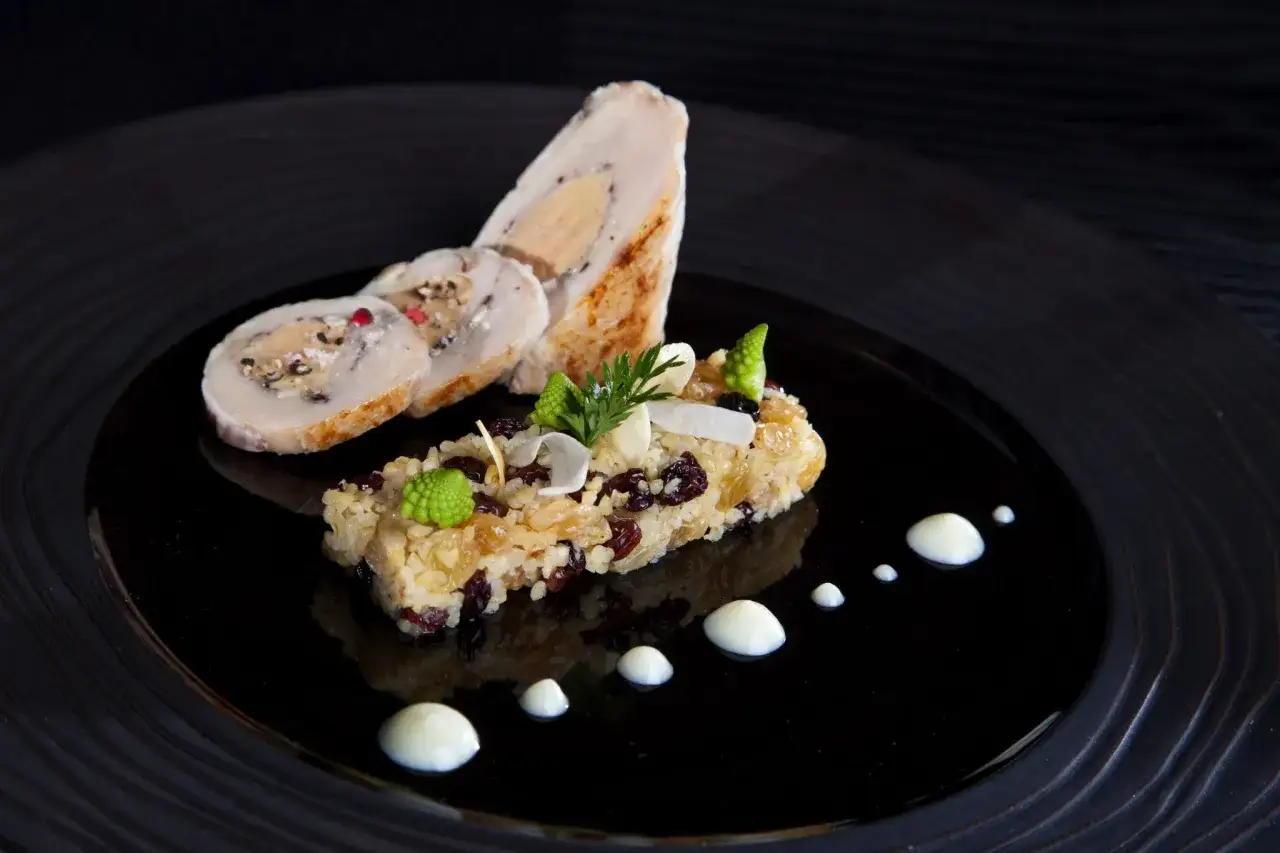 Un roulé de volaille farci au foie gras, accompagné d'un riz aux fruits secs et légumes verts, une spécialité Jura.