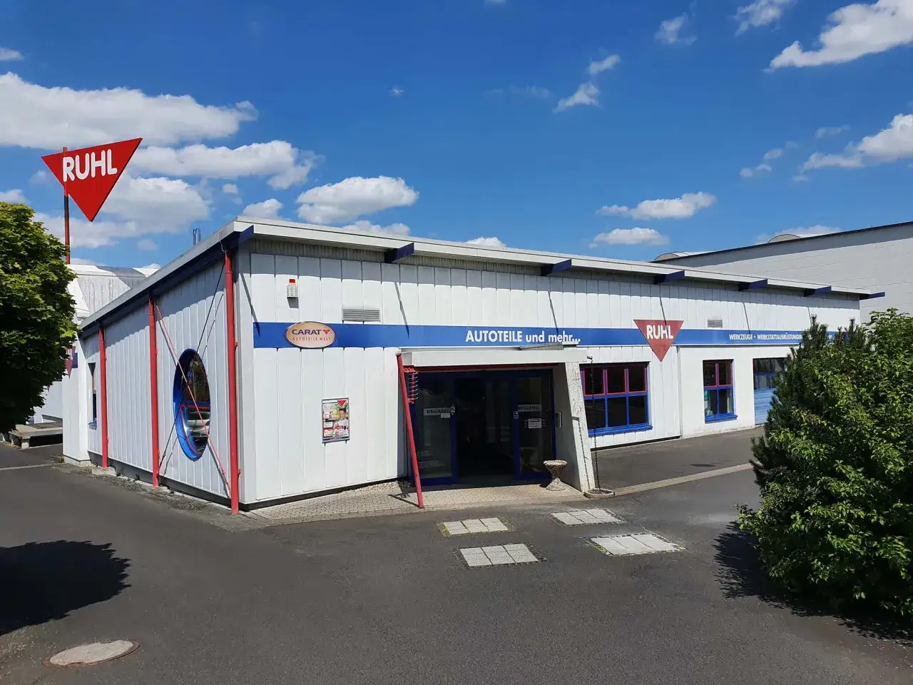 Gebäude von Ruhl Autoteile mit rotem Schild und blauem Schriftzug "AUTOTEILE und mehr...".