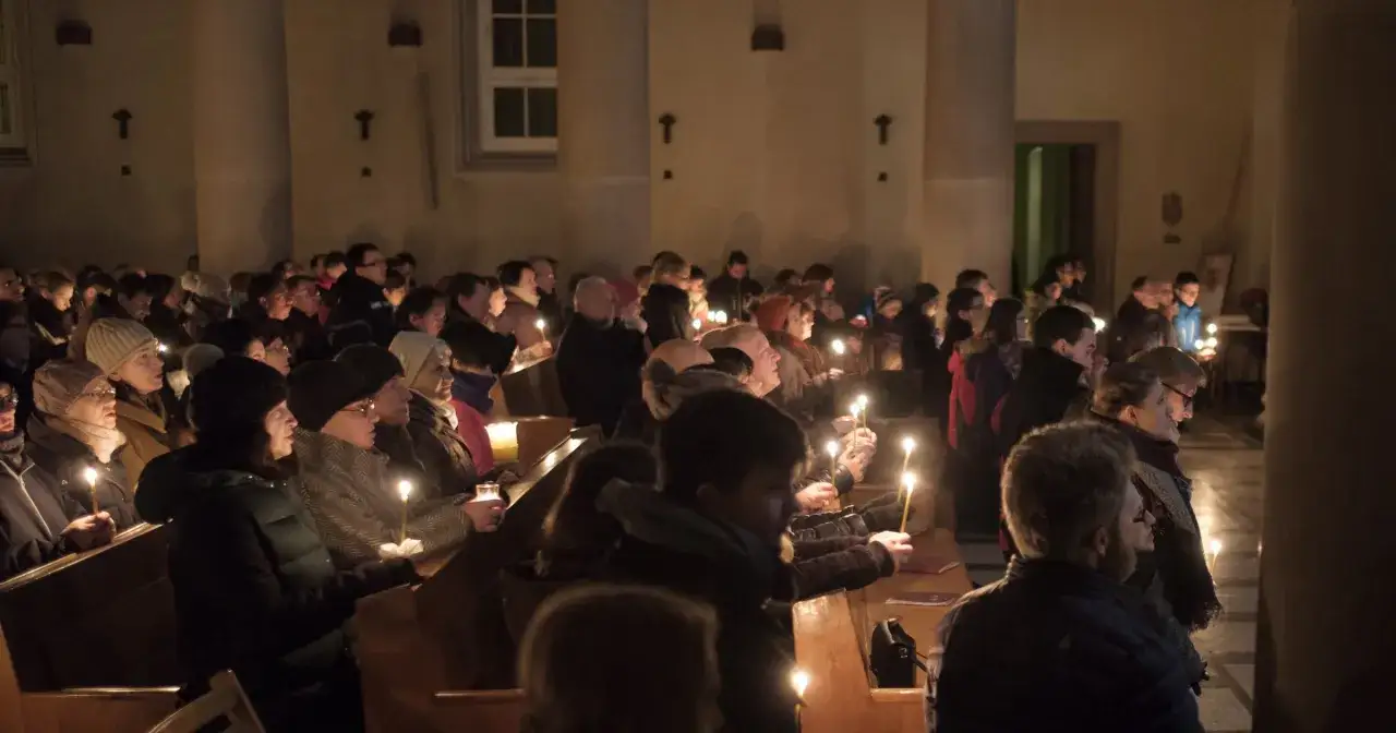 Ludzie z zapalonymi świecami w kościele podczas Rorat. Trwają one przez 24 dni Adwentu.