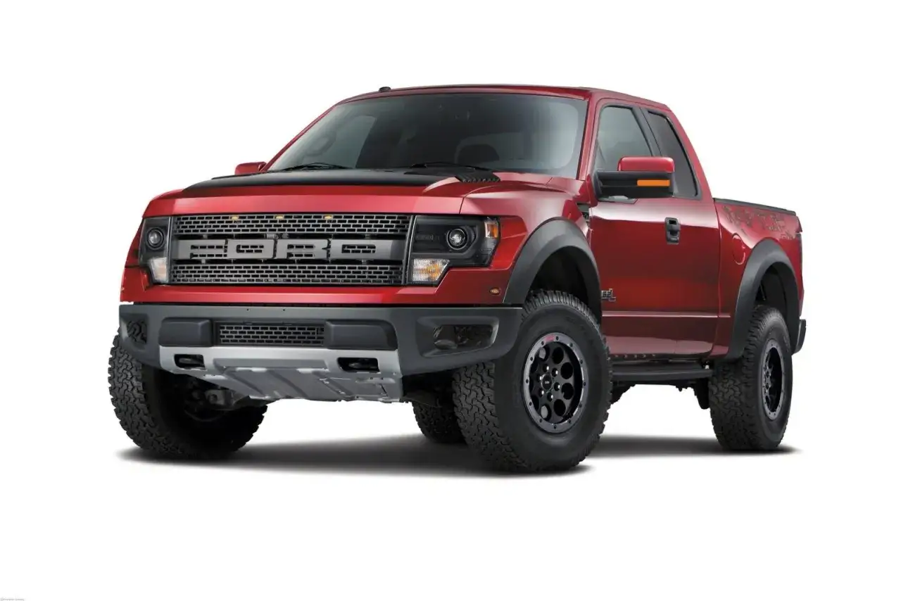 Czerwony Ford F-150 Raptor z czarną maską i felgami, gotowy na terenowe wyzwania.
