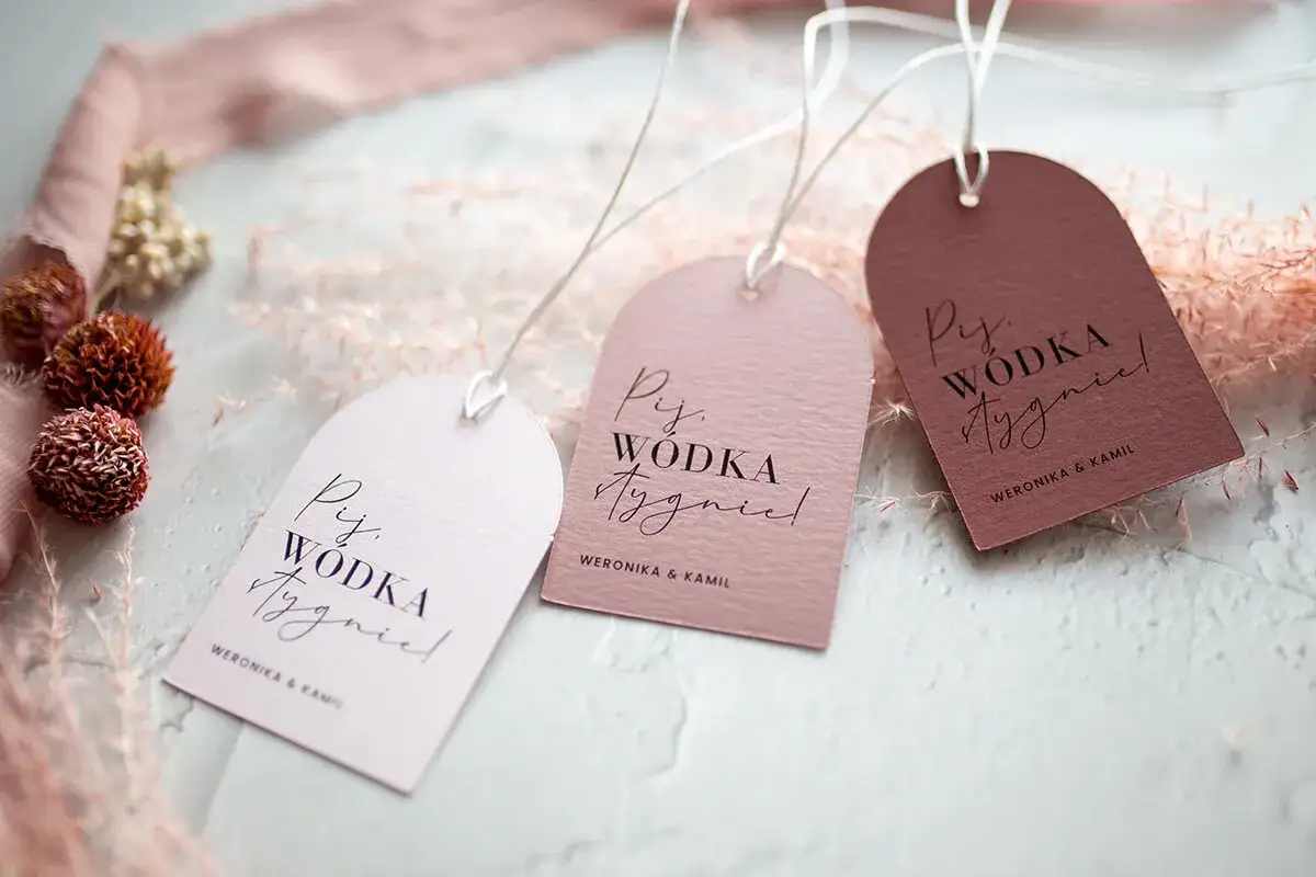 Eleganckie napisy na zawieszki na alkohol z imionami Weronika i Kamil. Idealne na wesele, by dodać uroku butelkom.