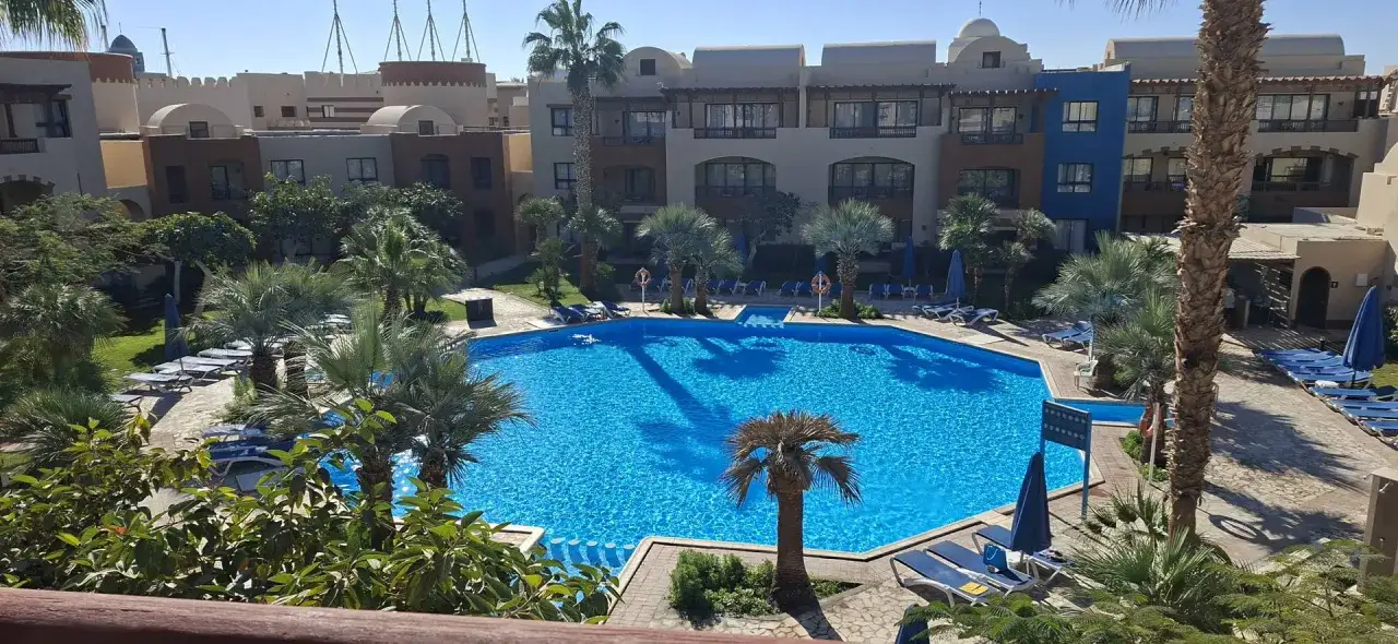 Basen w Radisson Individuals Marina Port Ghalib. Opinie gości chwalą ten tropikalny raj z palmami i krystalicznie czystą wodą.