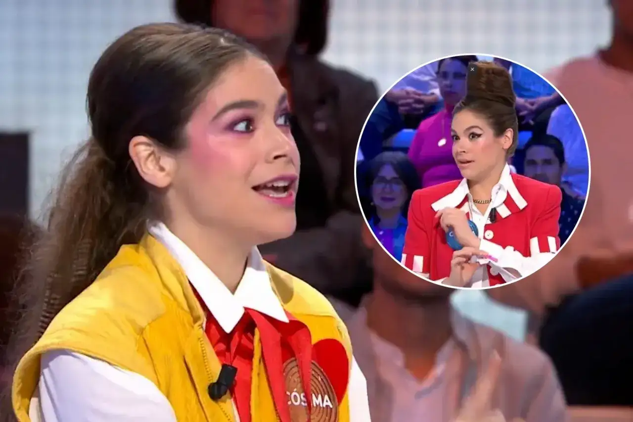 Cosima Ruiz de la Prada, con maquillaje llamativo y un chaleco amarillo, habla en un programa. En un círculo, se ve su peinado alto y chaqueta roja.