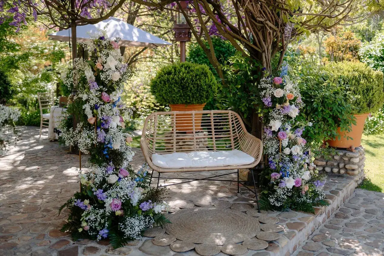 Un rincón idílico para bodas con arcos florales, un banco de mimbre y detalles rústicos. ¡Ideas originales boda!