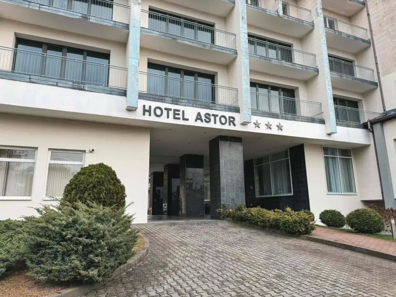 Hotel Astor Jastrzębia Góra – opinie o obiekcie z trzema gwiazdkami. Wejście do hotelu z podjazdem i zielenią.