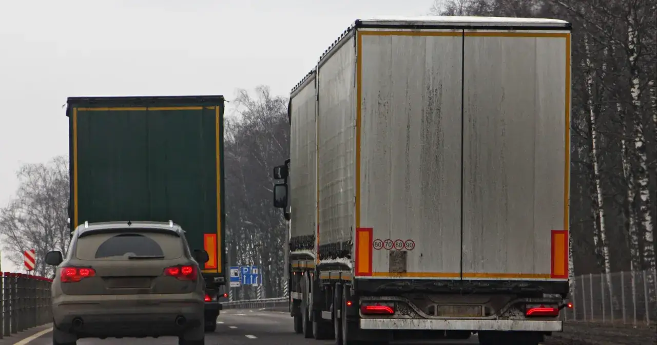 Ciężarówki na drodze, jeden samochód osobowy z tyłu. Od kiedy zakaz wyprzedzania dla ciężarówek, ruch jest wolniejszy.
