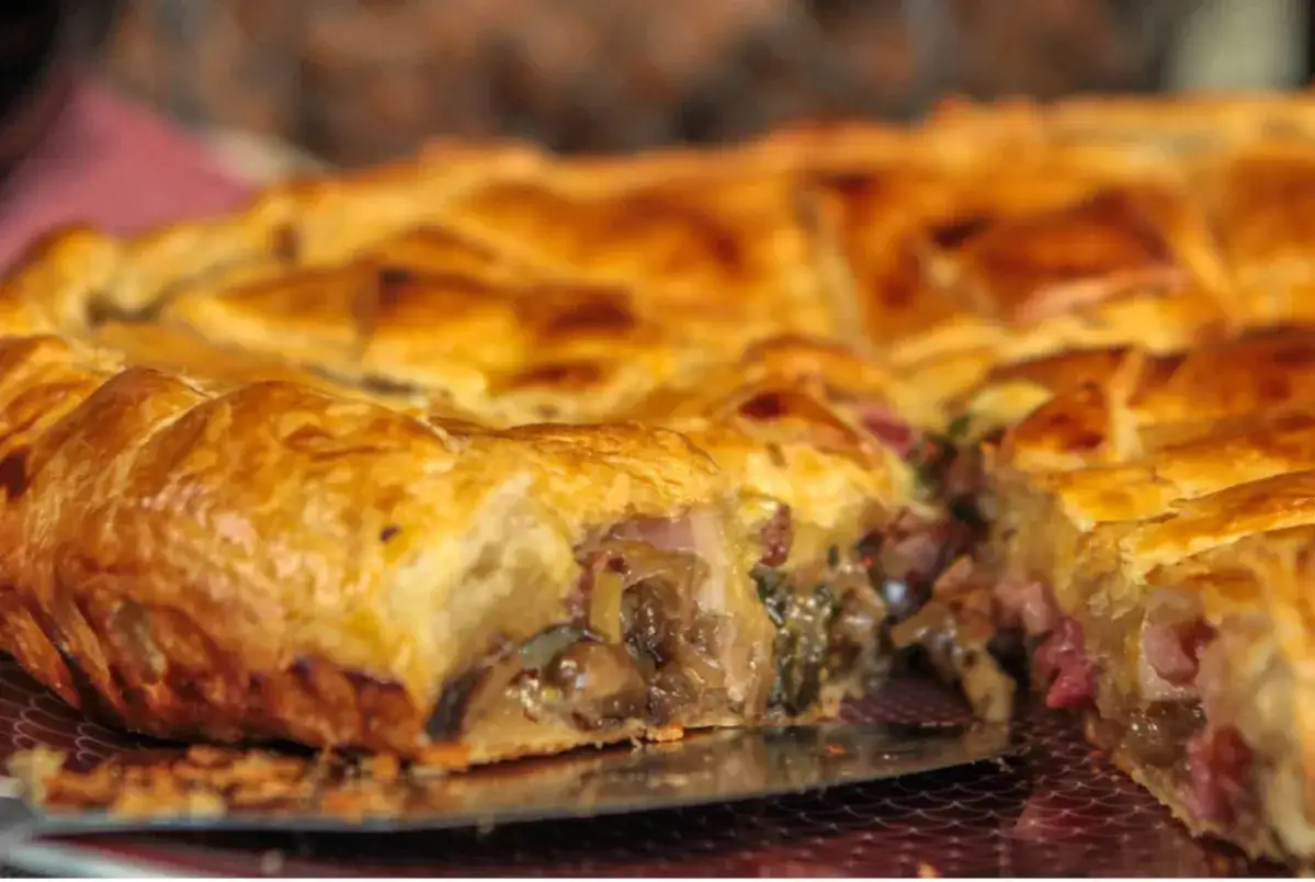 Une tourte dorée, garnie de champignons et de lardons, un délice de la saumur cuisine.