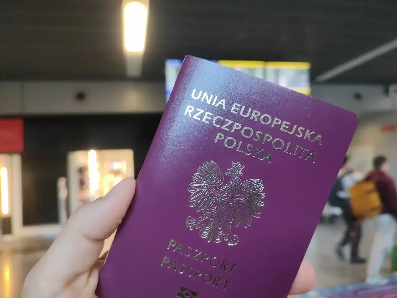 Polski paszport w dłoni, gotowy do podróży. Czy do UK potrzebny jest paszport? Tak, dla obywateli UE jest wymagany.
