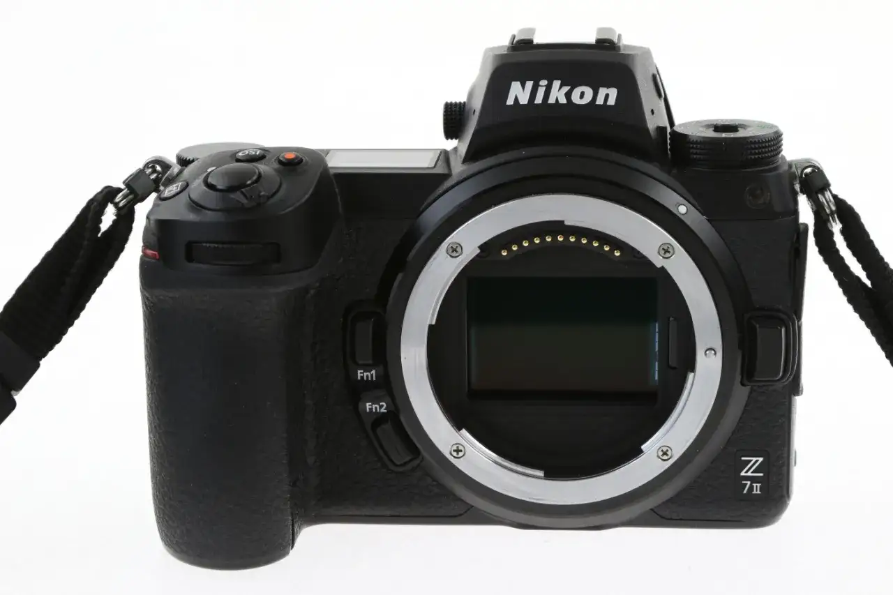 Czarny aparat Nikon Z7 III z obiektywem bez obiektywu, widoczny z przodu, z paskiem na nadgarstek.