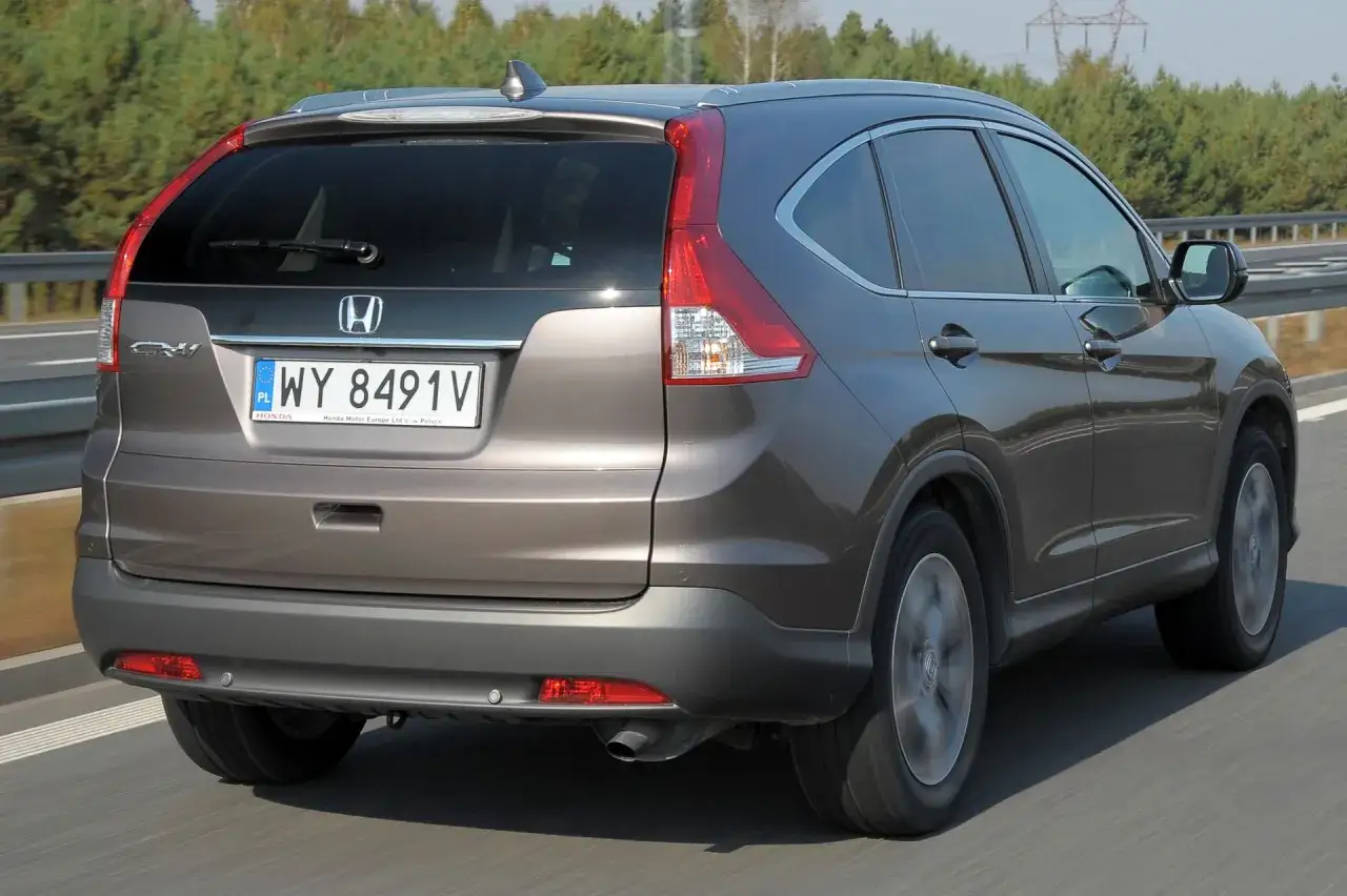 Honda CR-V 2.0 benzyna w kolorze brązowym jedzie po drodze.