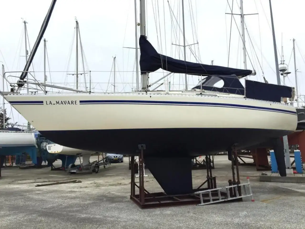 Segelboot "LA.MAVARE", eine Comfortina 32, steht auf Böcken im Hafen.