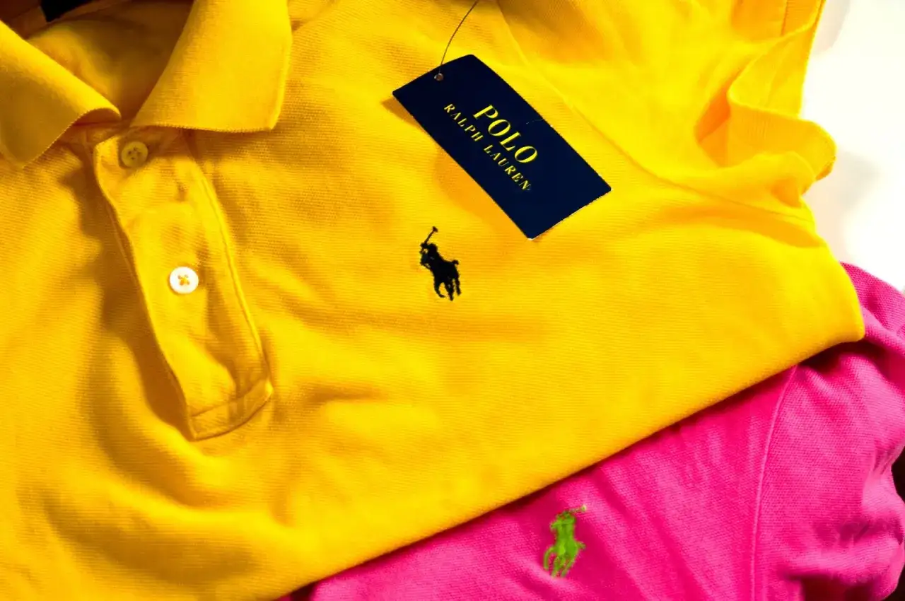 Żółta koszulka polo z czarnym polo ralph lauren znaczek. Obok różowa koszulka z zielonym logo.