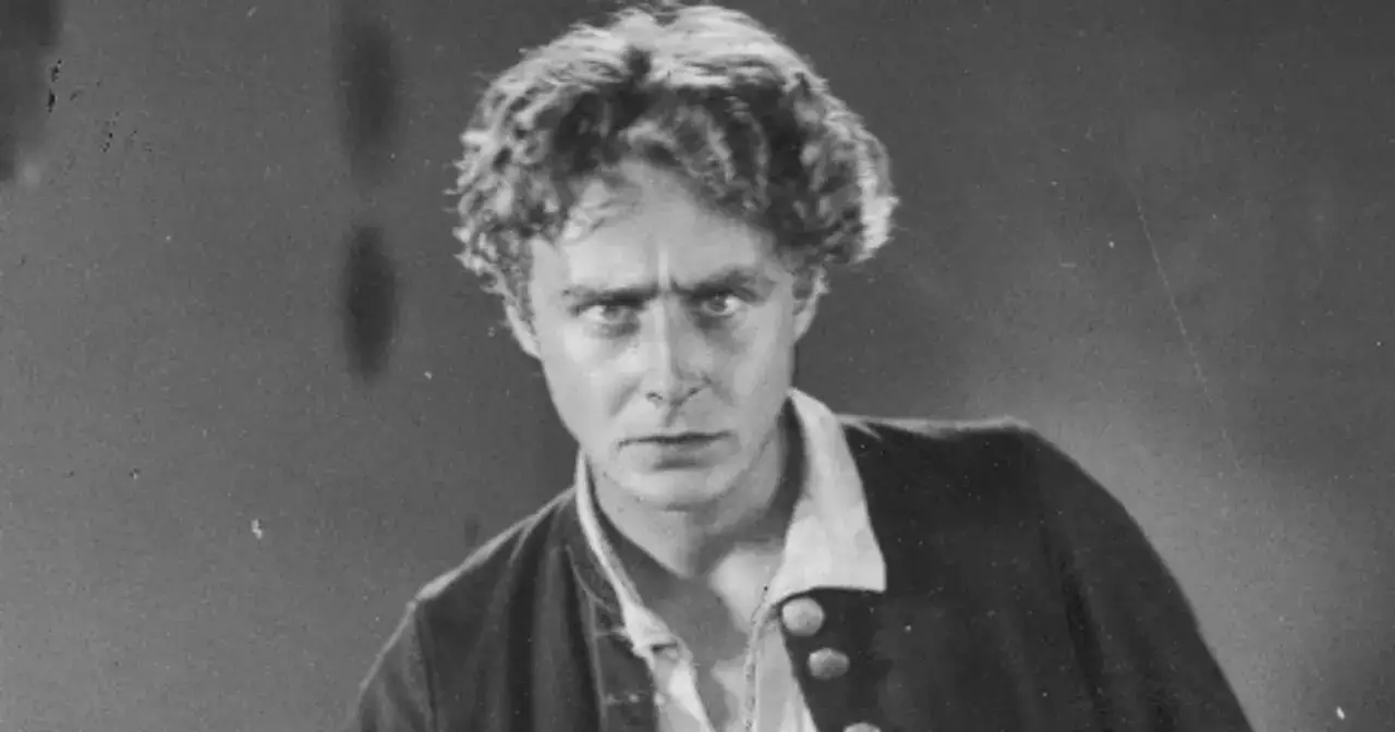 Portret mężczyzny z burzą loków, w stroju przypominającym historyczny. Czy to on, kto wynalazł kino?