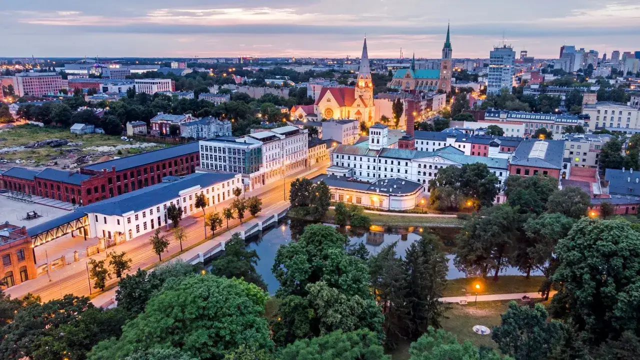 Widok na łódzką architekturę, w tym zabytkowe fabryki i kościoły. Idealne miejsce, by zobaczyć, co zwiedzić w Łodzi.
