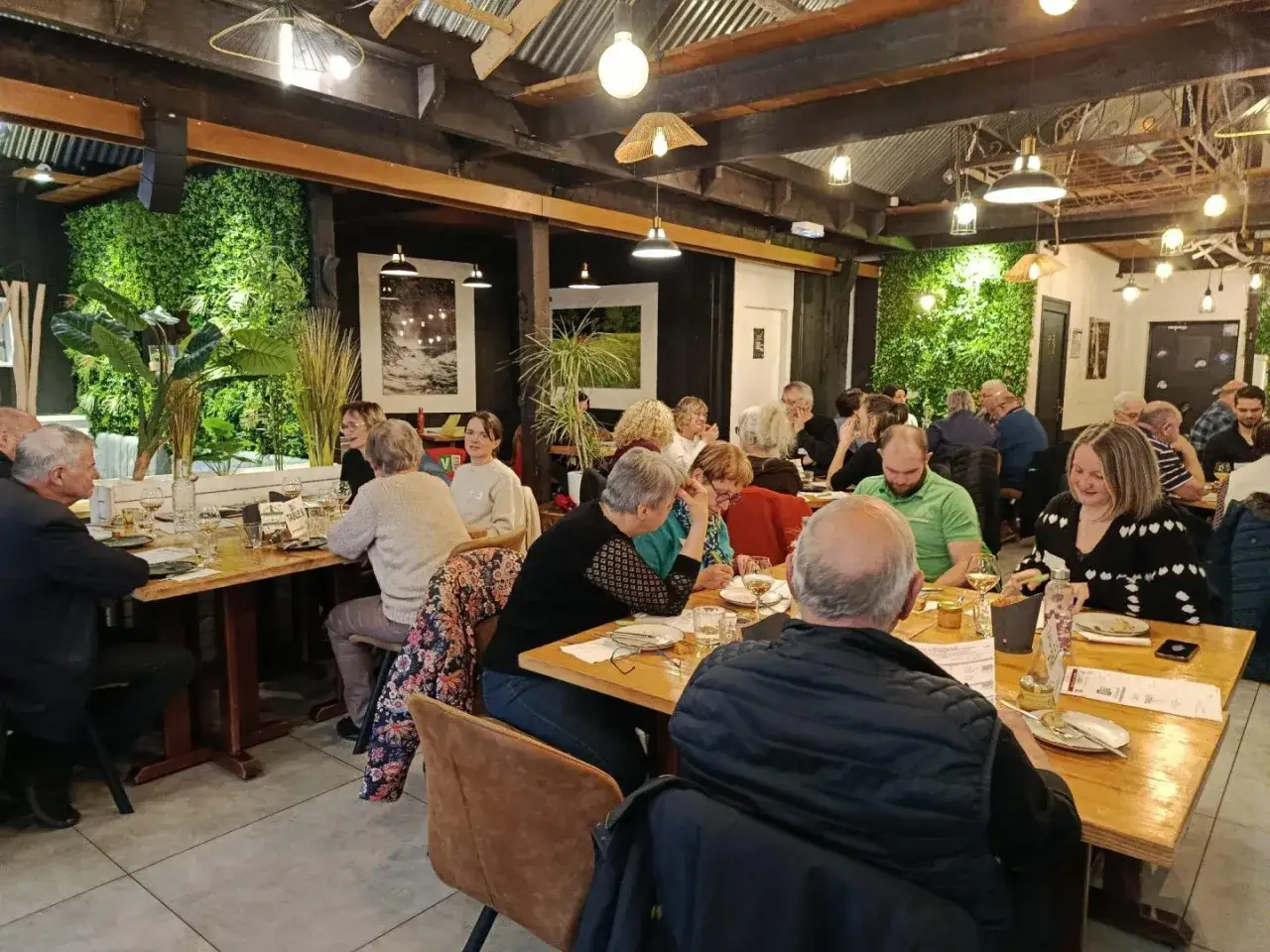 Un dîner convivial dans un restaurant à l'ambiance chaleureuse, où les convives savourent des mets qui incarnent la définition du "produit du terroir".