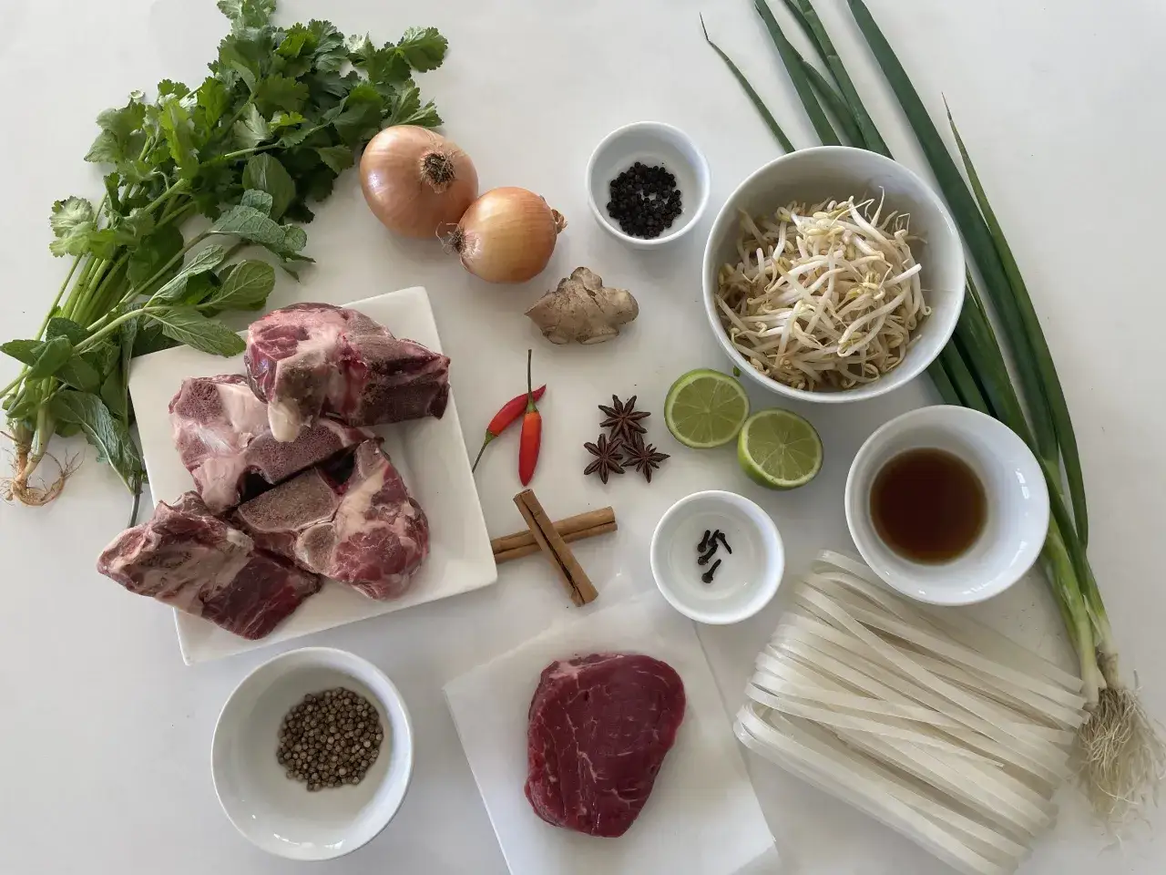 Składniki na pyszny pho przepis: wołowina, ryżowy makaron, cebula, imbir, chili, anyż, cynamon, goździki, kolendra, kiełki fasoli, limonka, dymka i przyprawy.