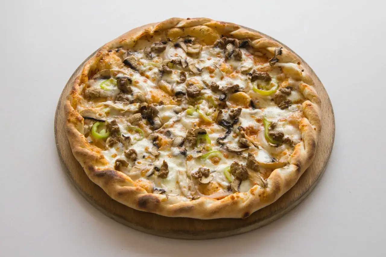 Apetyczna pizza z pieczarkami, mięsem i papryką. Czy to pizza rosso?